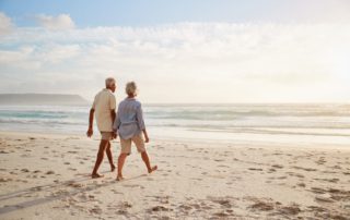 A couple walking along the beach, which is one of the top results when searching for what to do in Naples on a snowbird vacation.