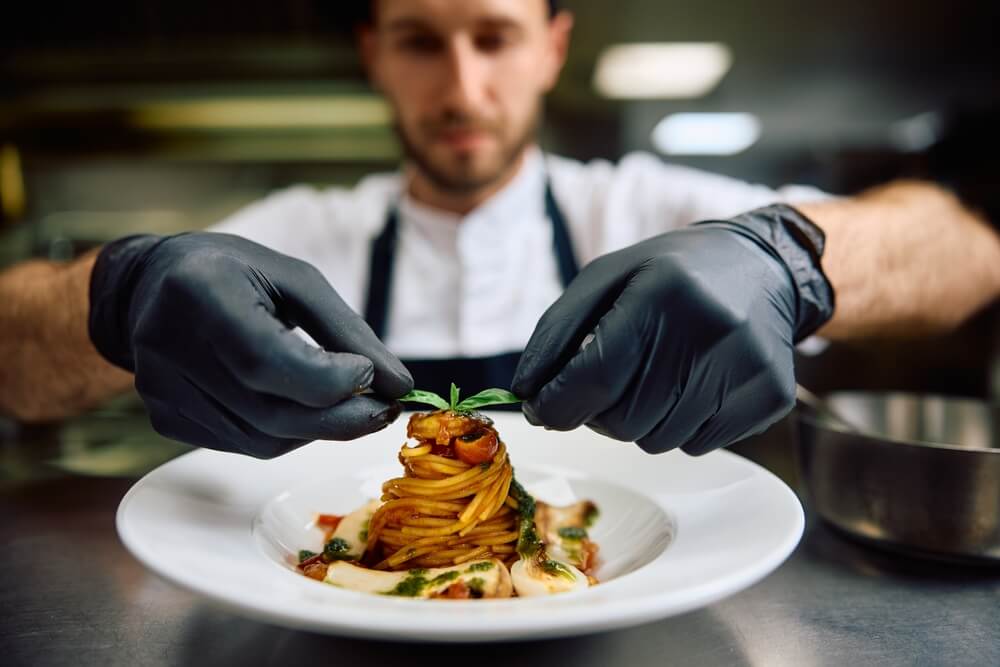 A chef plating up a dish at one of the best downtown Naples restaurants.